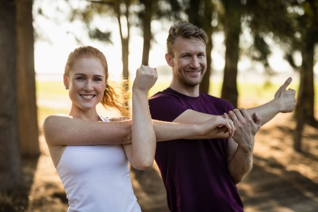 Couple smiling while stretching.