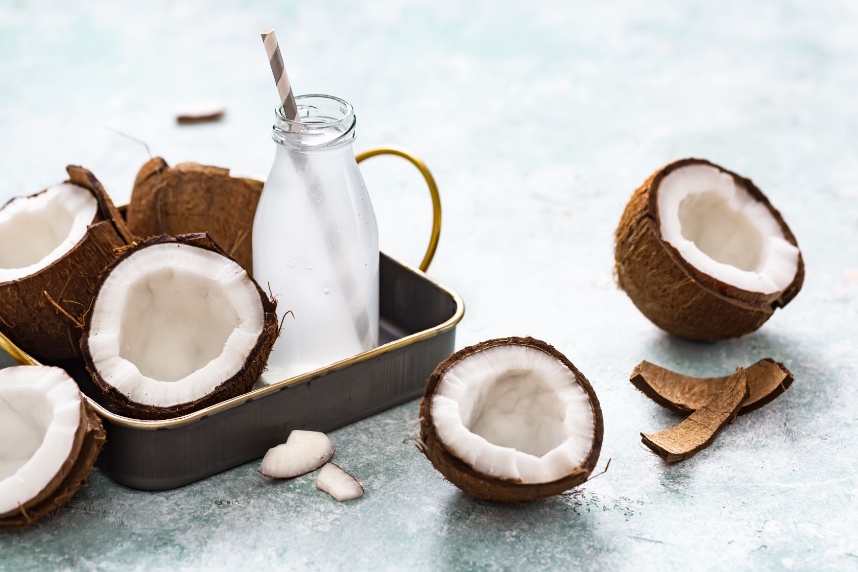 Coconuts and coconut water sitting on a tray.