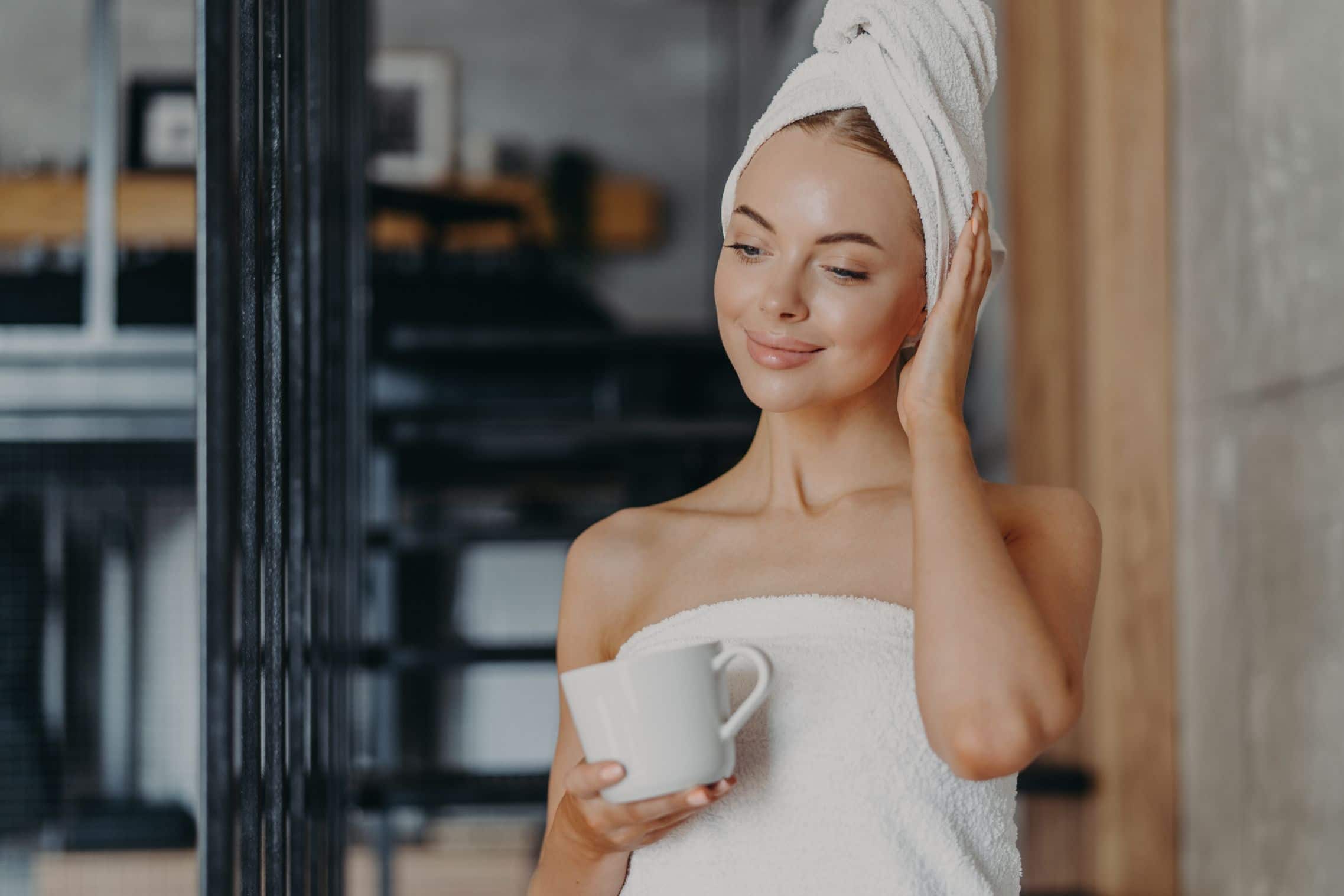 Happy woman with towel wrapped around hair.
