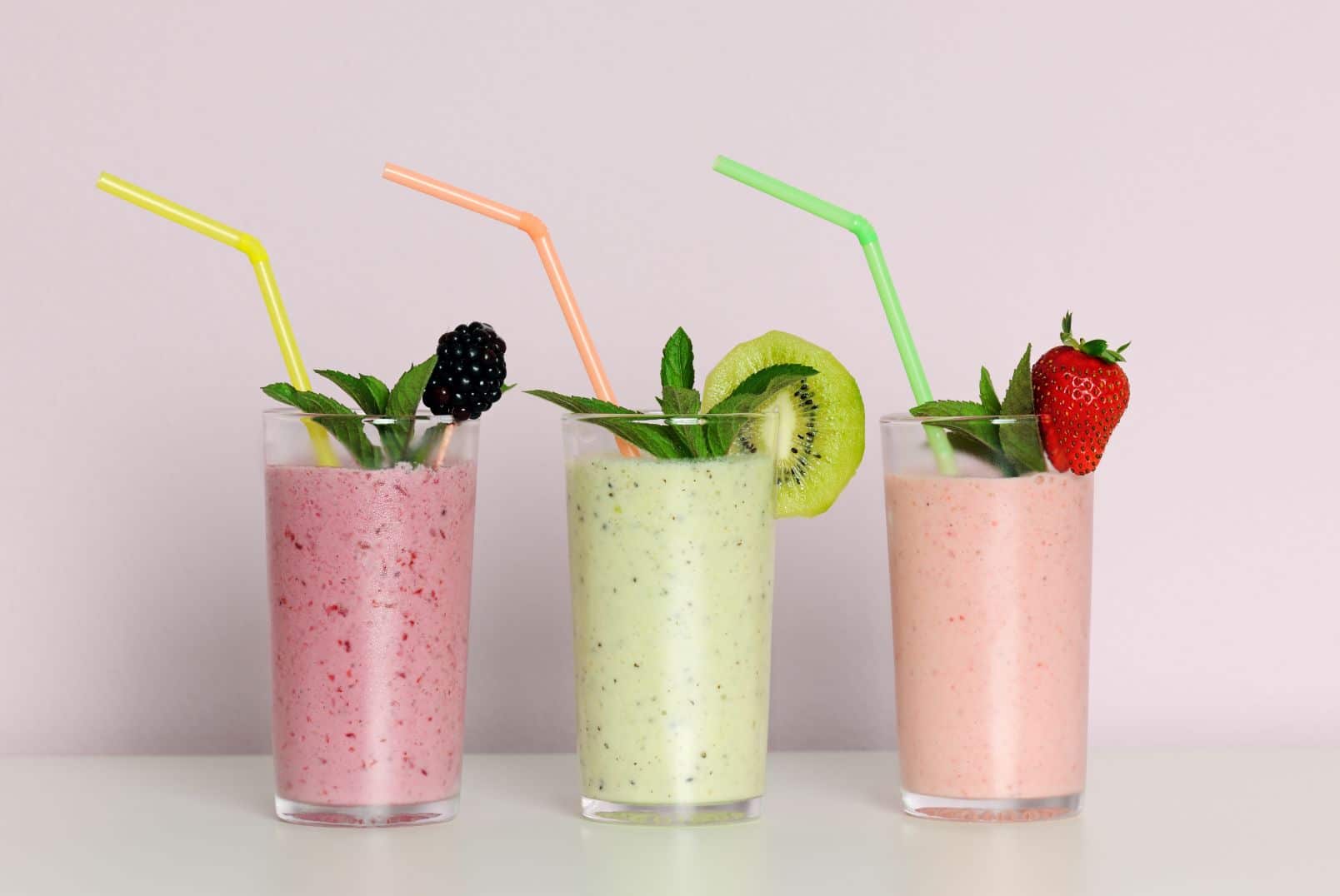 Three Fruit Smoothies with Straws in a Row